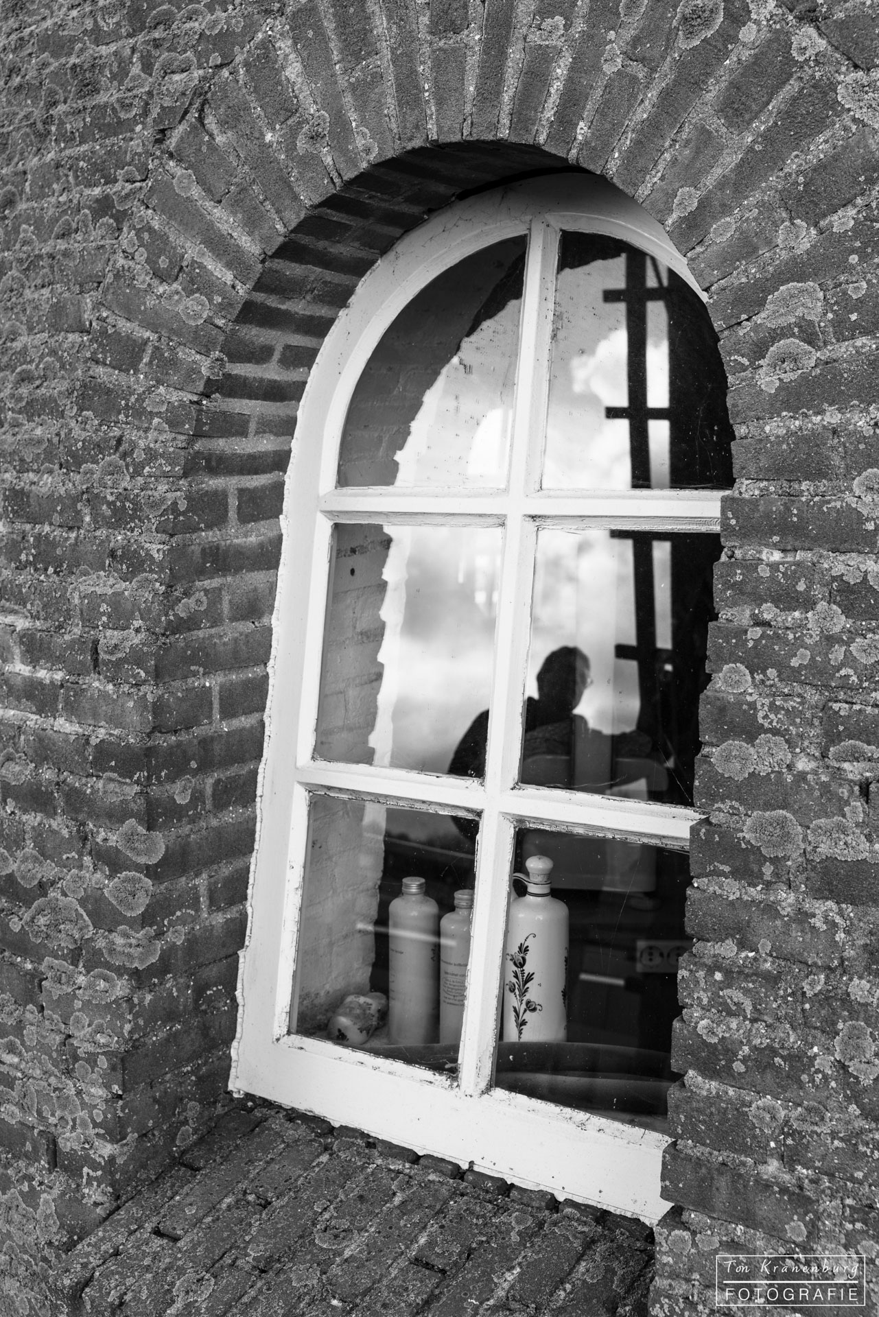 Raam molen de Lelie met weerspiegeling van Molenaar.